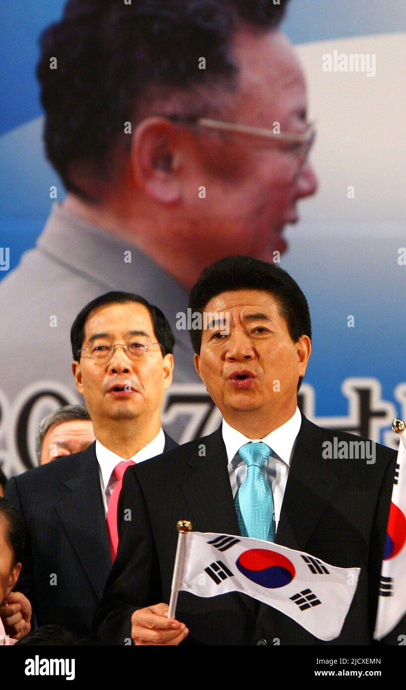 Il presidente della Corea del Sud Roh Moo-hyun (F) e il primo ministro Han Duck-Soo(B) cantano un canto sull'unificazione della Corea in una cerimonia di benvenuto dopo l'arrivo all'ufficio doganale, immigrazione e quarantena (CIQ) della Corea del Sud vicino alla zona smilitarizzata di Paju, a nord di Seoul, il 4 ottobre 2007. Giovedì i leader della Corea del Nord e della Corea del Sud si sono impegnati a portare la pace all'ultima frontiera della guerra fredda cercando di avviare colloqui con la Cina e gli Stati Uniti per porre formalmente fine alla guerra di Corea del 1950-1953. Foto Stock