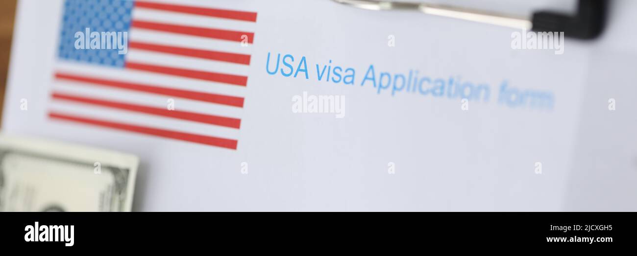 Documenti per il visto americano e il passaporto con soldi che giacciono sul primo piano del tavolo Foto Stock