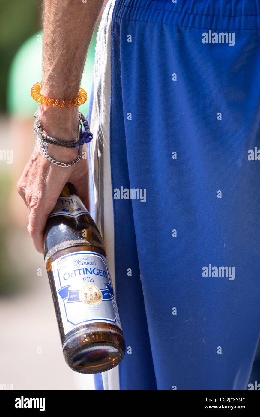 Gotha, Germania. 16th giugno 2022. Un uomo porta una bottiglia di birra  Oettinger ai margini di una dimostrazione di fronte al werktor per la  conservazione dei posti di lavoro presso la birreria