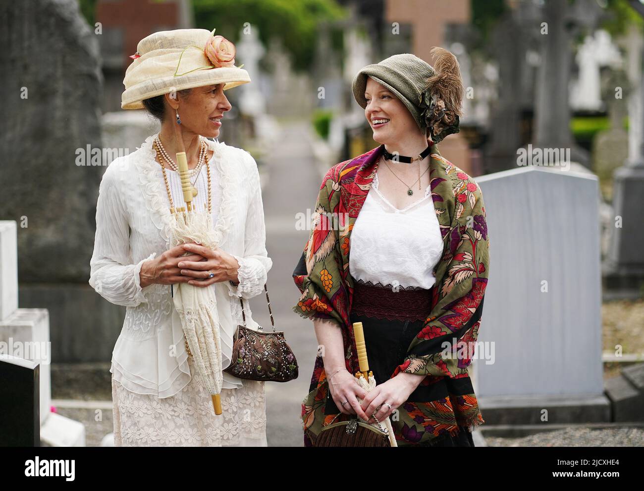 Anamaria Croce (a sinistra) e Deirdre Kelly vagano tra le lapidi mentre assistono a una rievocazione di Joycestagers dal capitolo 'Hades' di Ulisse al Cimitero Glasnevin, Dublino, come parte delle celebrazioni annuali di Bloomsday. Bloomsday è una celebrazione della vita dello scrittore irlandese James Joyce, osservato annualmente in tutto il mondo il 16 giugno, il giorno del suo romanzo di 1922 Ulysses si svolge nel 1904, la data della sua prima uscita con sua moglie-a-essere Nora Barnacle. Il giorno prende il nome dal suo protagonista Leopold Bloom. Data foto: Mercoledì 25 agosto 2021. Foto Stock