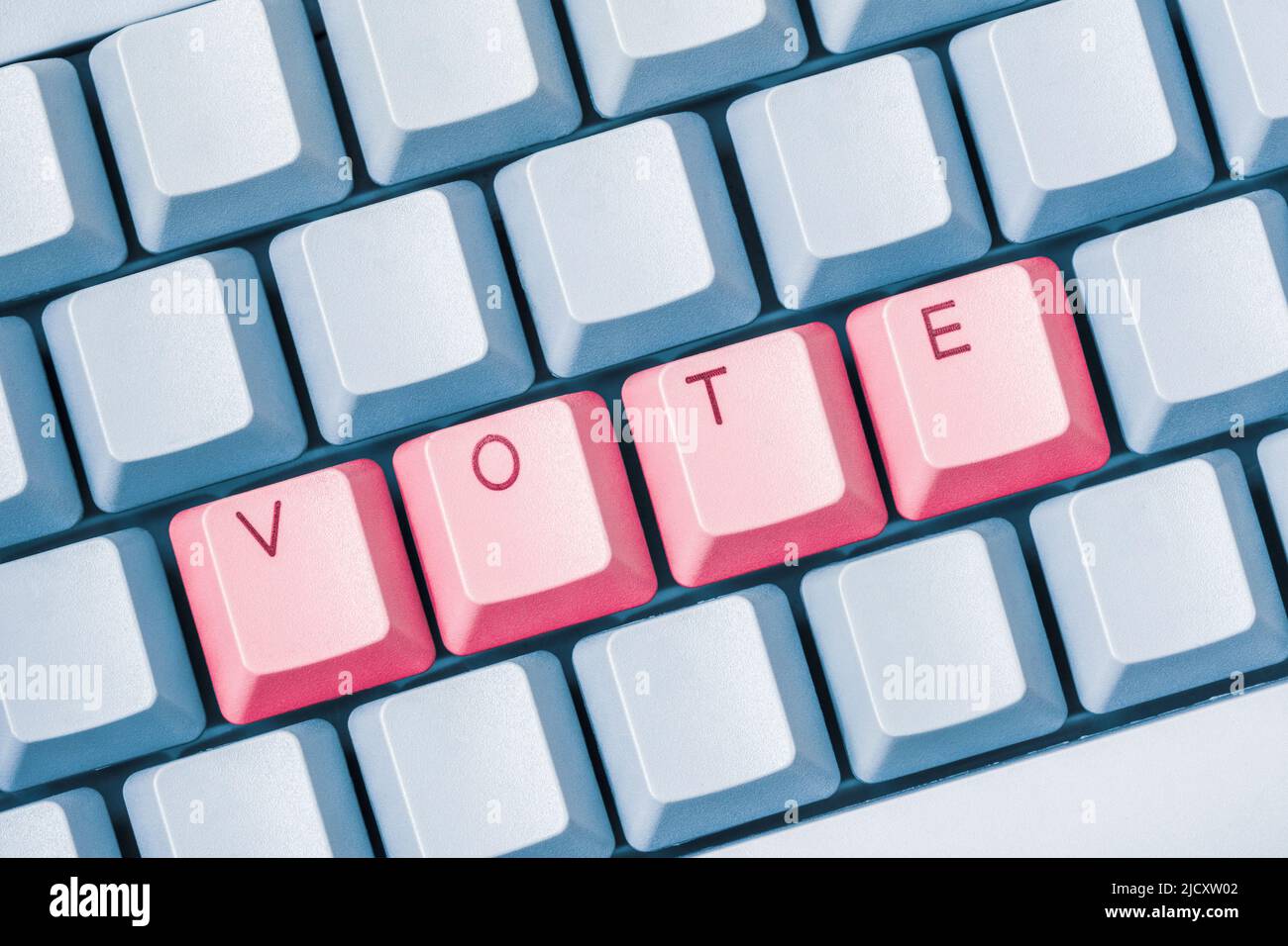 CONSENTE DI VOTARE i tasti rossi su una tastiera blu del pc. Partecipazione online alle elezioni, alle votazioni su Internet e ai concetti di e-voting. Foto Stock
