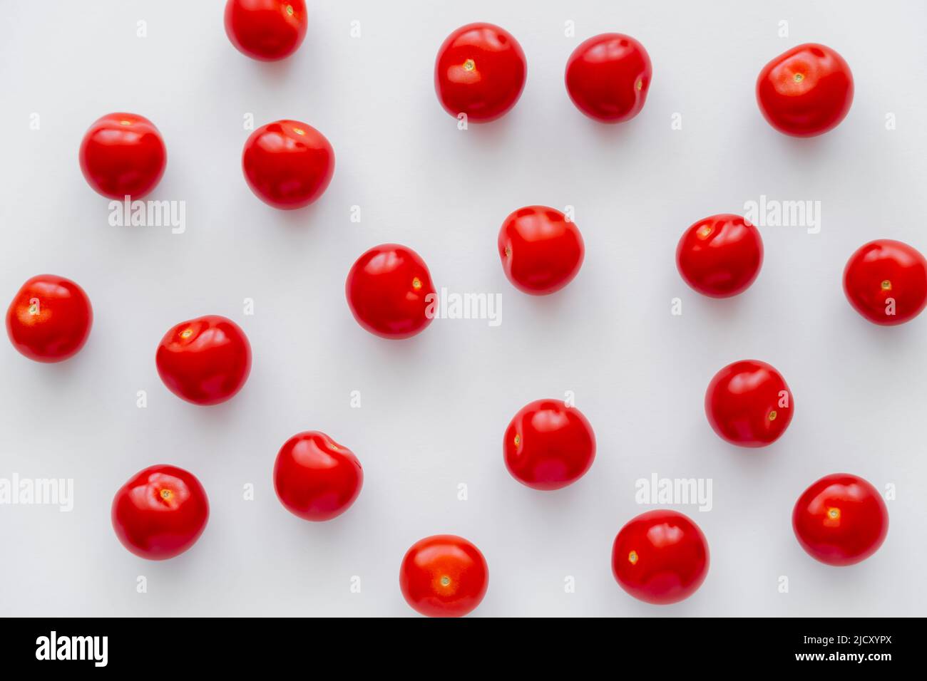Piatto con pomodori ciliegini su sfondo bianco Foto Stock