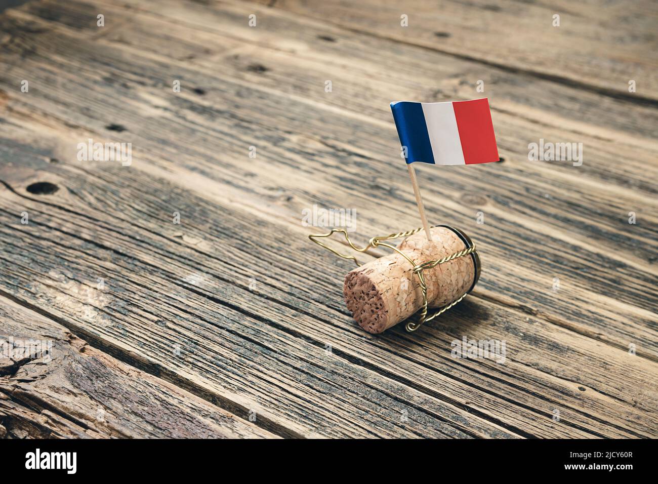 Bottiglia di champagne in sughero con bandiera francese su un vecchio tavolo in legno, giorno della Bastiglia e giorno nazionale francese 14 luglio concetto Foto Stock