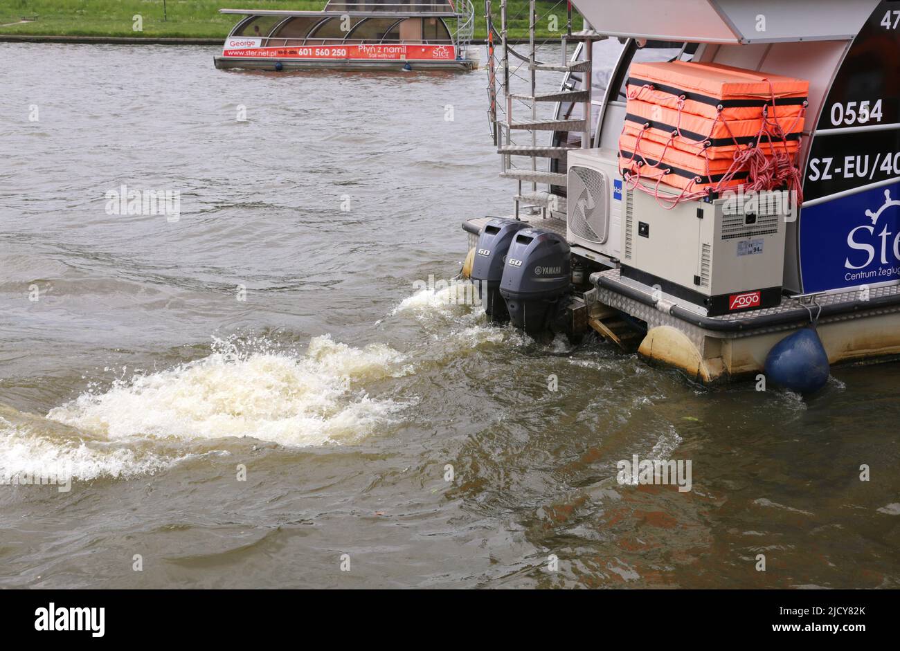 Cracovia. Cracovia. Polonia. Svegliati a sinistra dietro la nave fluviale con motore fuoribordo. Foto Stock