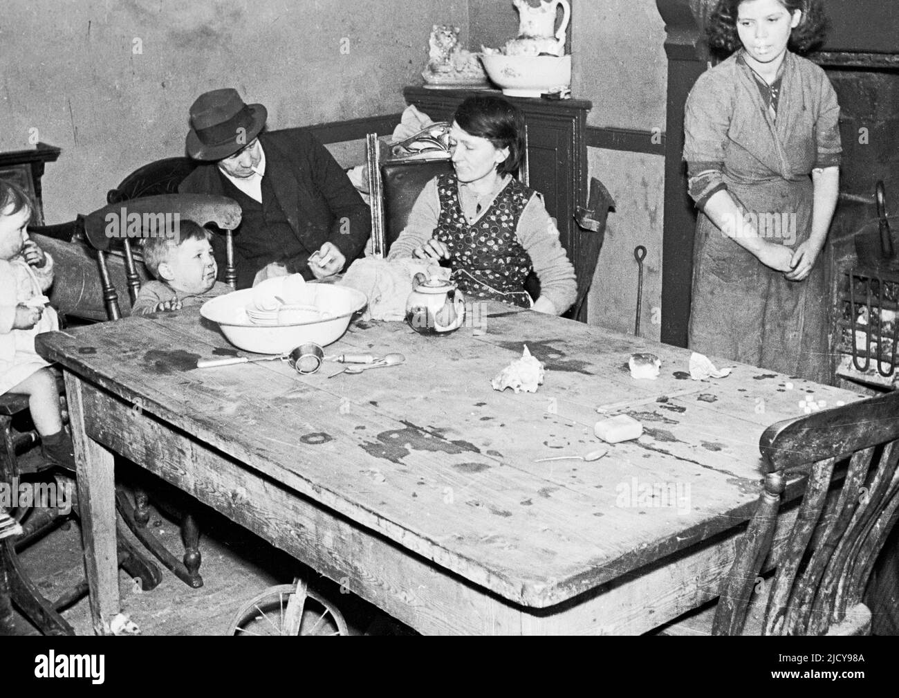 1940s, storico, post-ww2, familiari femminili, giovani e anziani, Seduti intorno a un tavolo di legno e fuoco reale in una piccola stanza all'interno di una casa nel villaggio minerario di Trehafod, Galles del Sud, Regno Unito. Foto Stock