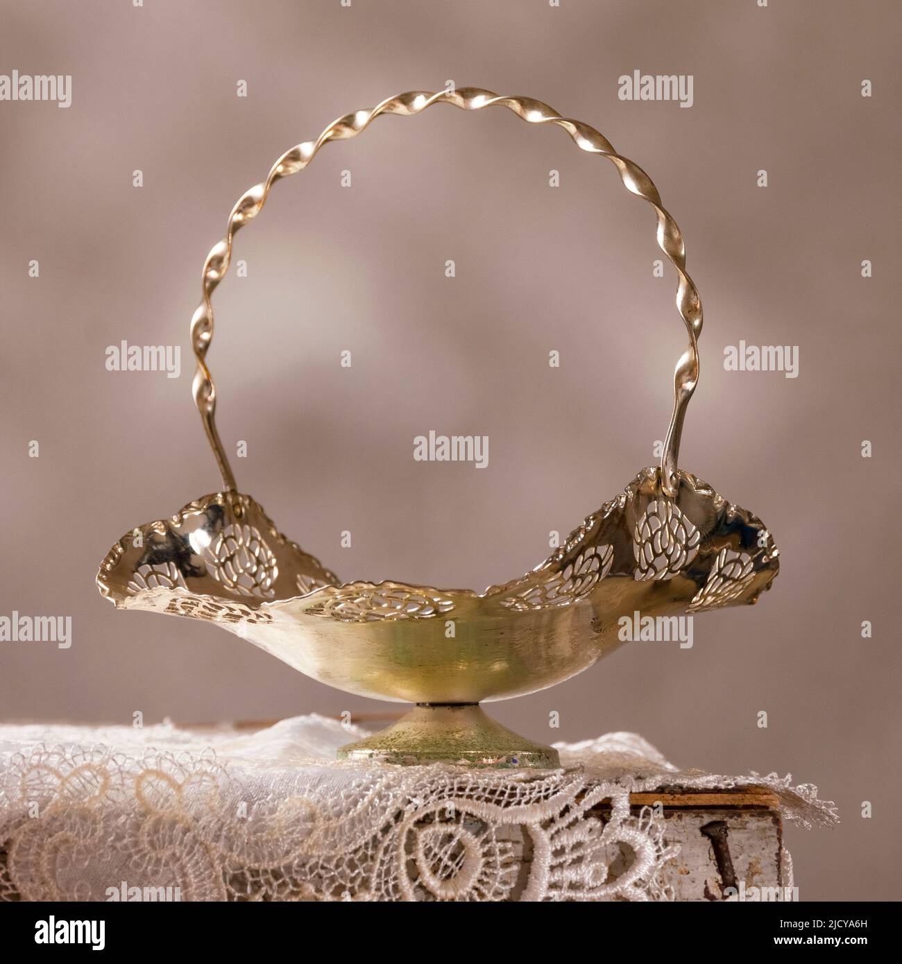 Antico piatto d'argento e tovaglia ricamata su un tavolo in legno Foto Stock