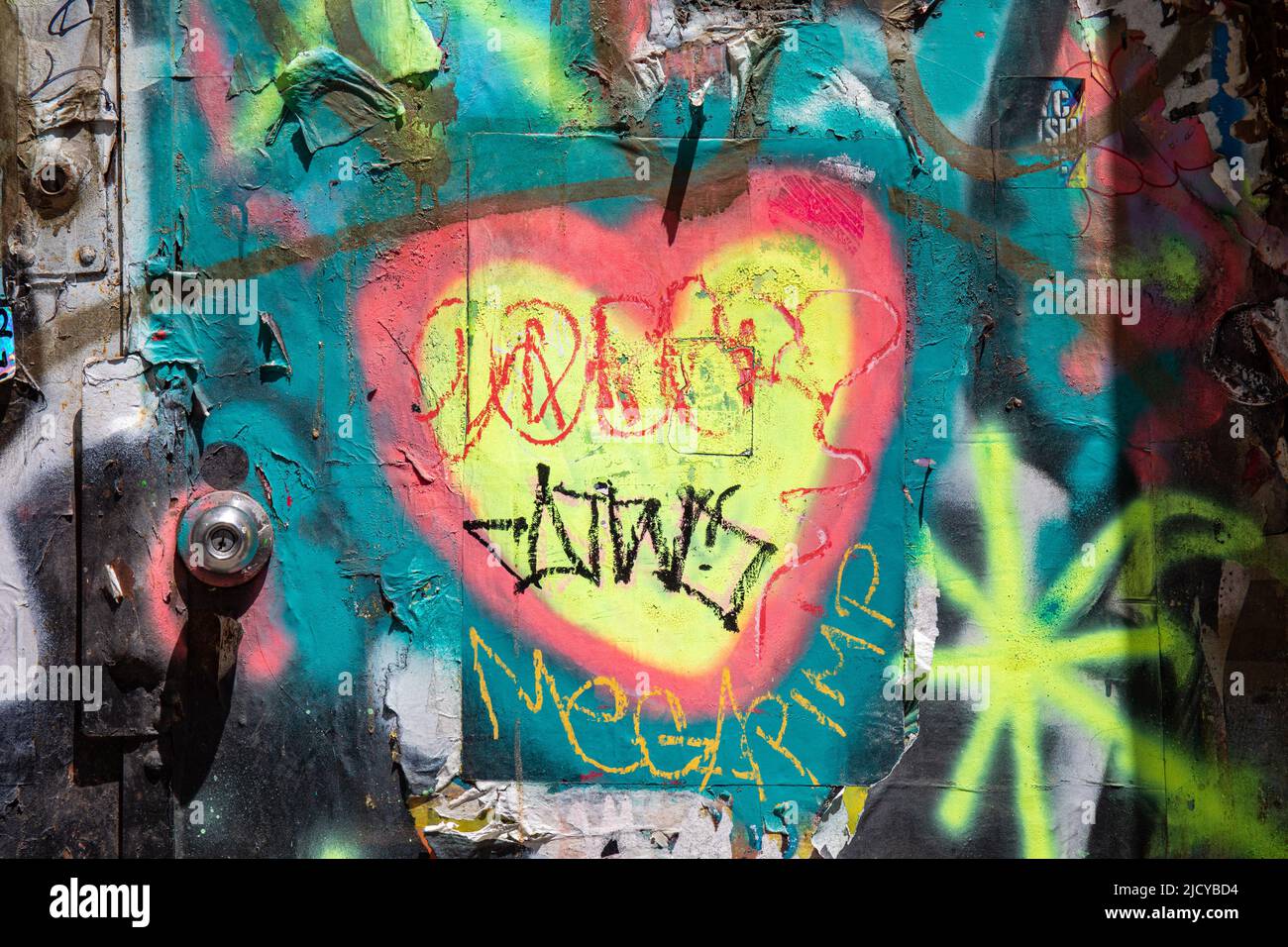 Street art. Graffiti a cuore giallo sulla porta esterna nel lato Lower East di New York City, Stati Uniti d'America. Foto Stock