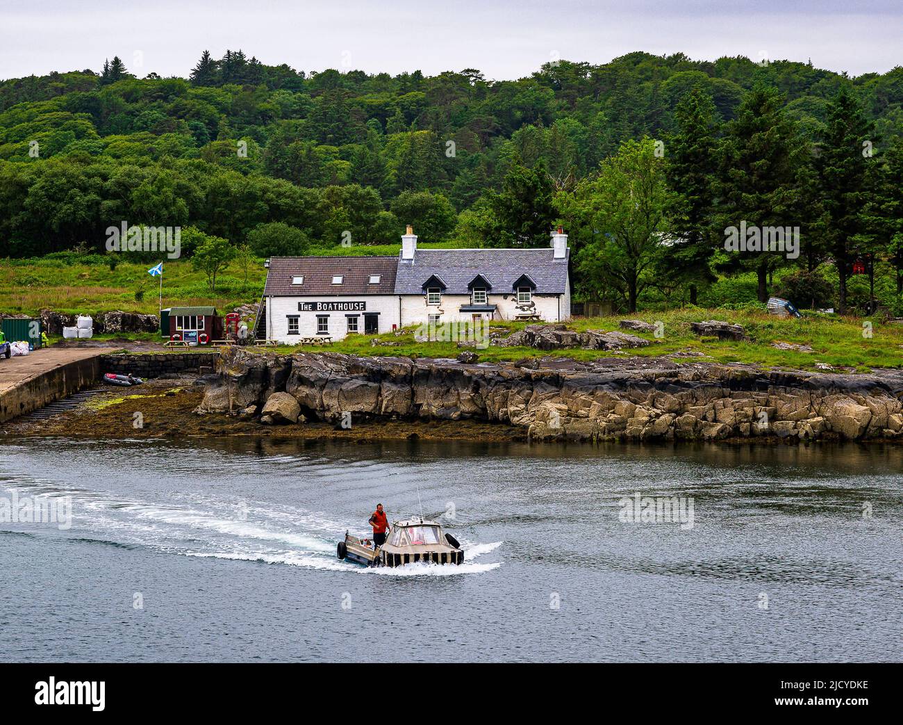 Traghetto Ulva, Isola di Mull, Scozia – Vista attraverso l'Isola di Ulva, con un traghetto passeggeri che attraversa il ristorante Boathouse Inn sull'isola di Ulva Foto Stock