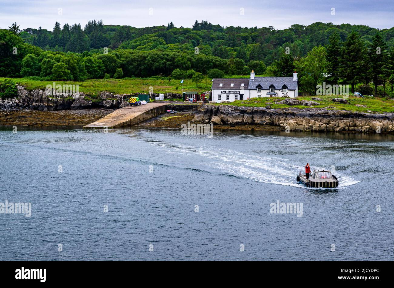 Traghetto Ulva, Isola di Mull, Scozia – Vista attraverso l'Isola di Ulva, con un traghetto passeggeri che attraversa il ristorante Boathouse Inn sull'isola di Ulva Foto Stock