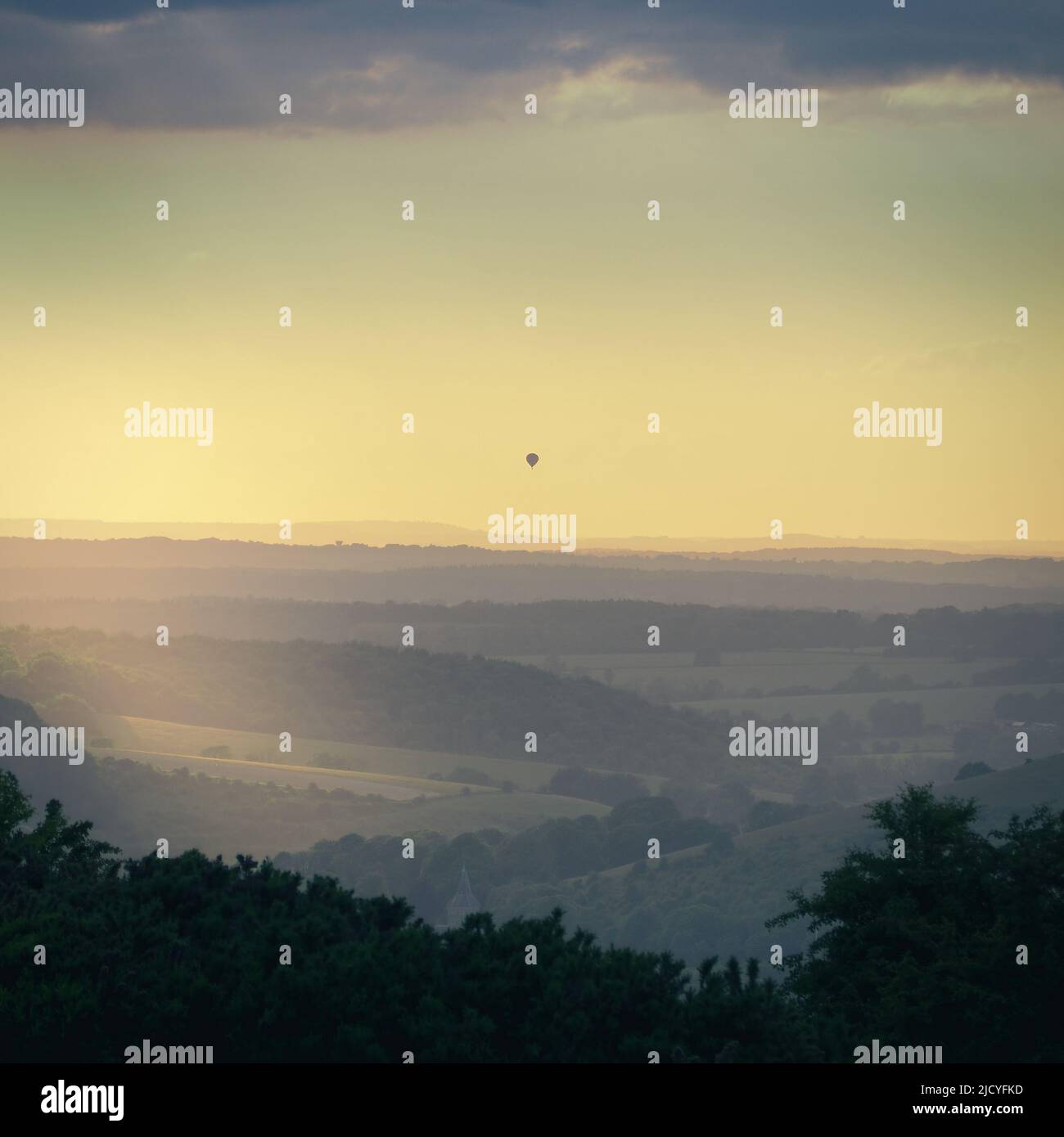 Vista serale dalla cima di Butser Hill con mongolfiera all'orizzonte, Hampshire Foto Stock