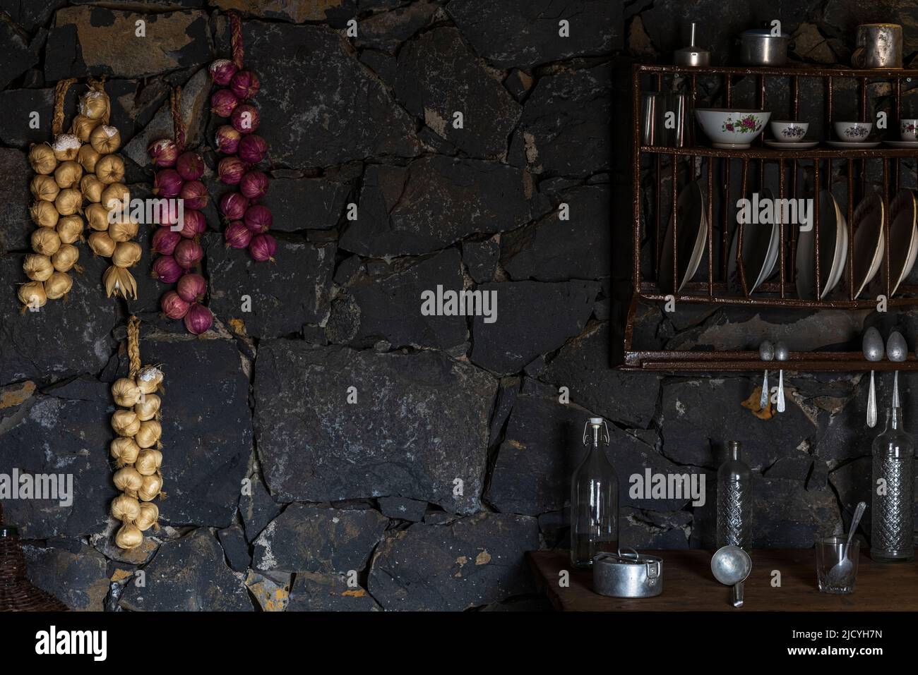Corde di cipolle e aglio insieme agli utensili da cucina dell'Eco Museum che mostrano manufatti e mostre dello stile di vita agricolo e rurale del Th Foto Stock