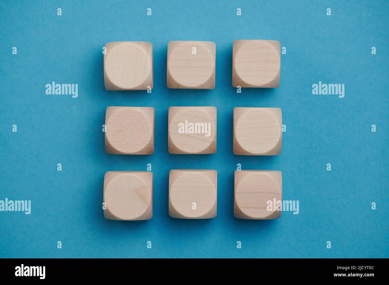 nove cubi di legno su sfondo blu in tre file, spazio copia Foto Stock