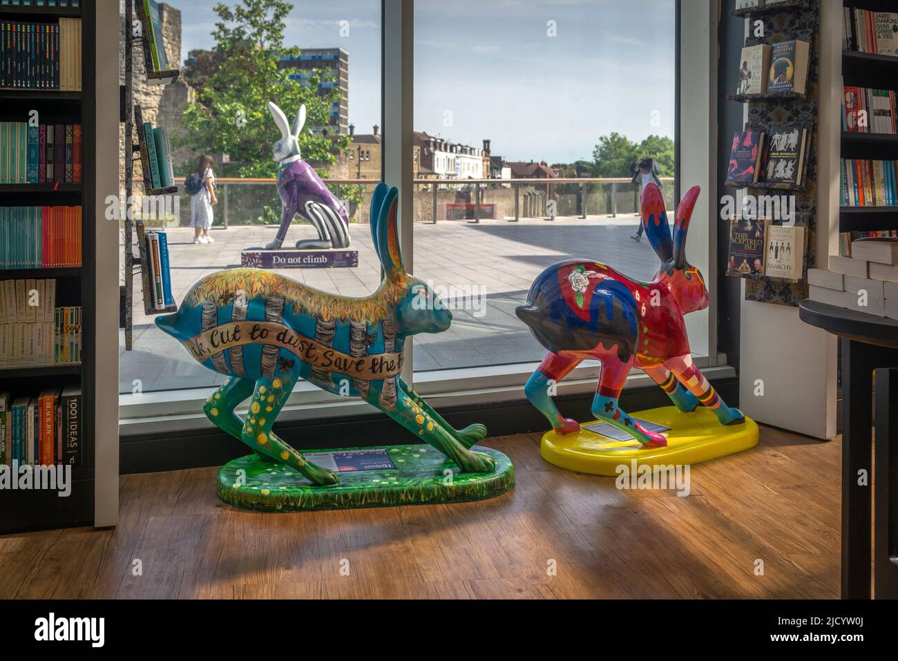 Southampton, Regno Unito. 16 giugno 2022. Hares of Hampshire Art Trail, evento di arte pubblica attraverso Southampton e Winchester che mostra sculture giganti e piccole di lepri sponsorizzate dal Murray Parish Trust and Wild in Art. Qui sono raffigurate due piccole sculture di lepri all'interno della libreria Waterstones e una gigantesca scultura di lepri all'esterno del centro commerciale WestQuay Foto Stock