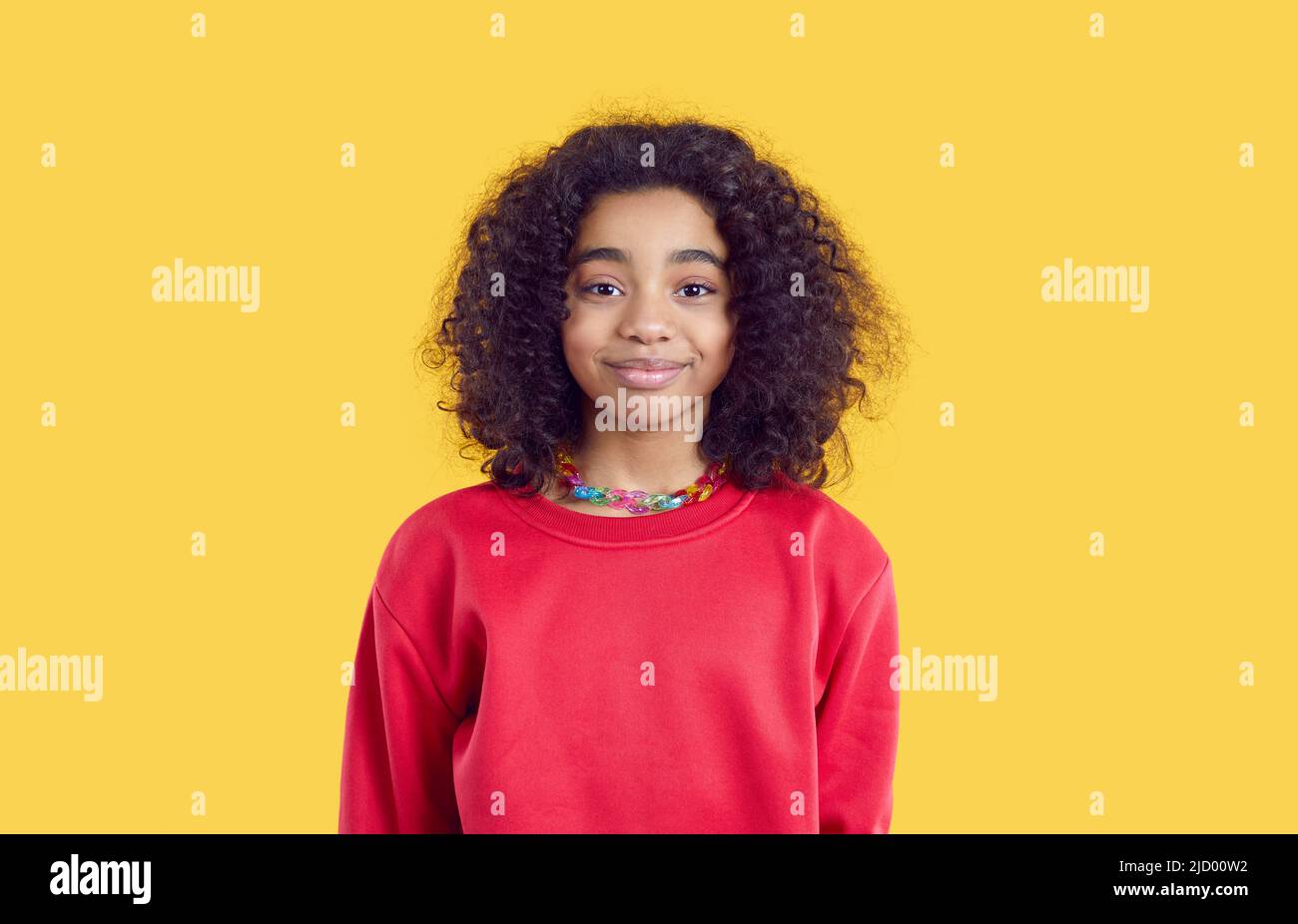 Felice sorridente bambino afroamericano in felpa rossa isolato su sfondo giallo Foto Stock