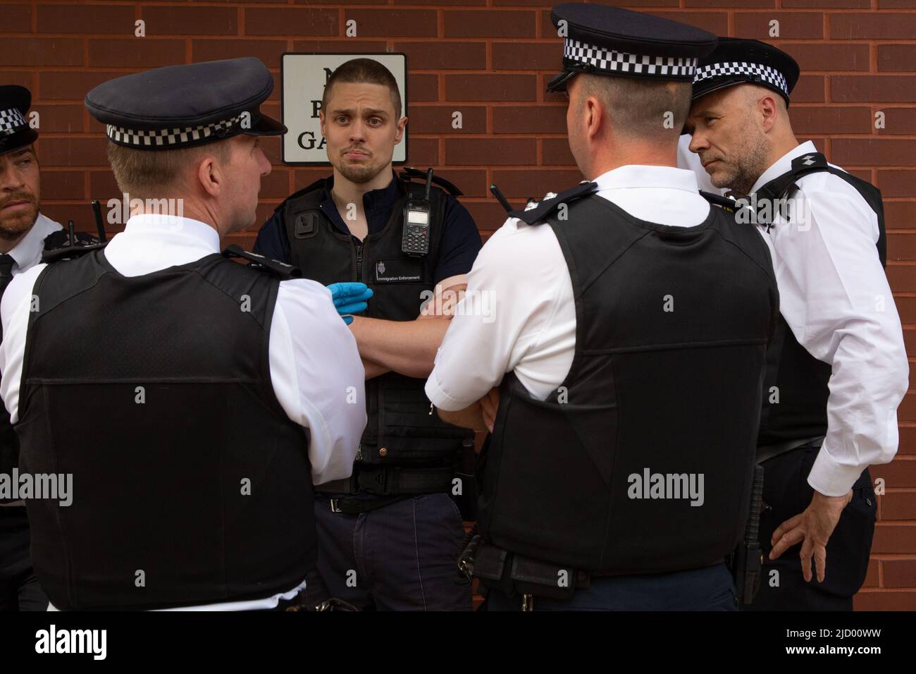 11 giugno 2022 la polizia parla con un ufficiale di immigrazione (C) durante un raid di immigrazione a Evan Cook Close, Queens Road. L'uomo nigeriano arrestato per Foto Stock