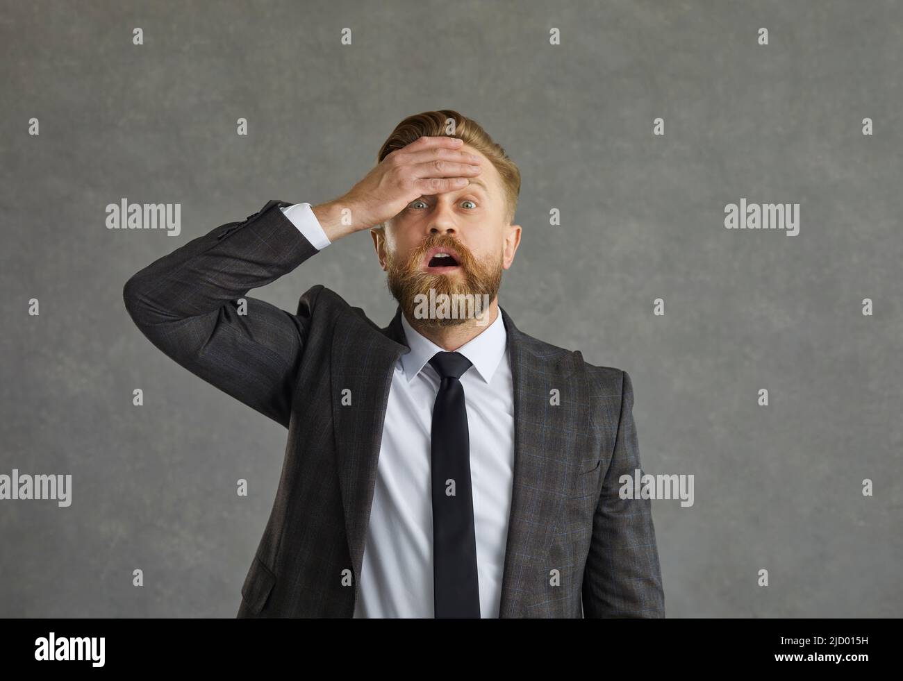 L'uomo d'affari schiaffe di mano sulla fronte mentre si rende conto che ha fatto un errore o dimenticato qualcosa Foto Stock