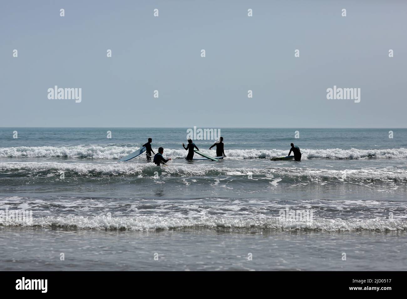 Spagna-Castellon, 16 aprile 2022: Gruppo di persone che imparano a nuotare su una tavola da surf sul Mar Mediterraneo. Foto Stock