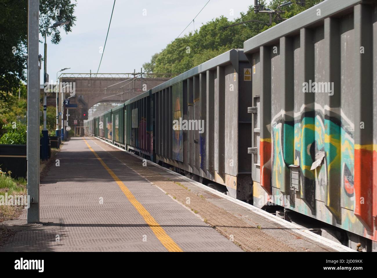 Il treno merci fa polvere mentre passa attraverso la stazione di Chelford Foto Stock