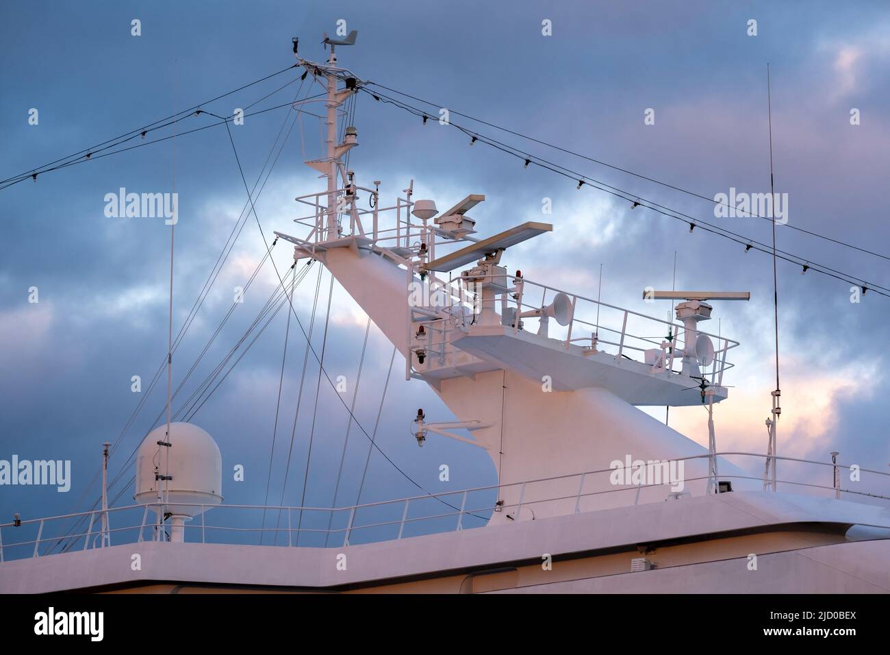 Helsinki / Finlandia - 16 GIUGNO 2022: Primo piano dell'albero radar di una nave contro le nuvole di tempesta scura durante il tramonto Foto Stock