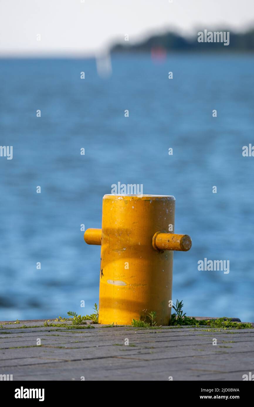 Helsinki / Finlandia - 15 GIUGNO 2022: Primo piano di un bullard ormeggio contro un mare azzurro. Una piccola isola all'orizzonte. Foto Stock