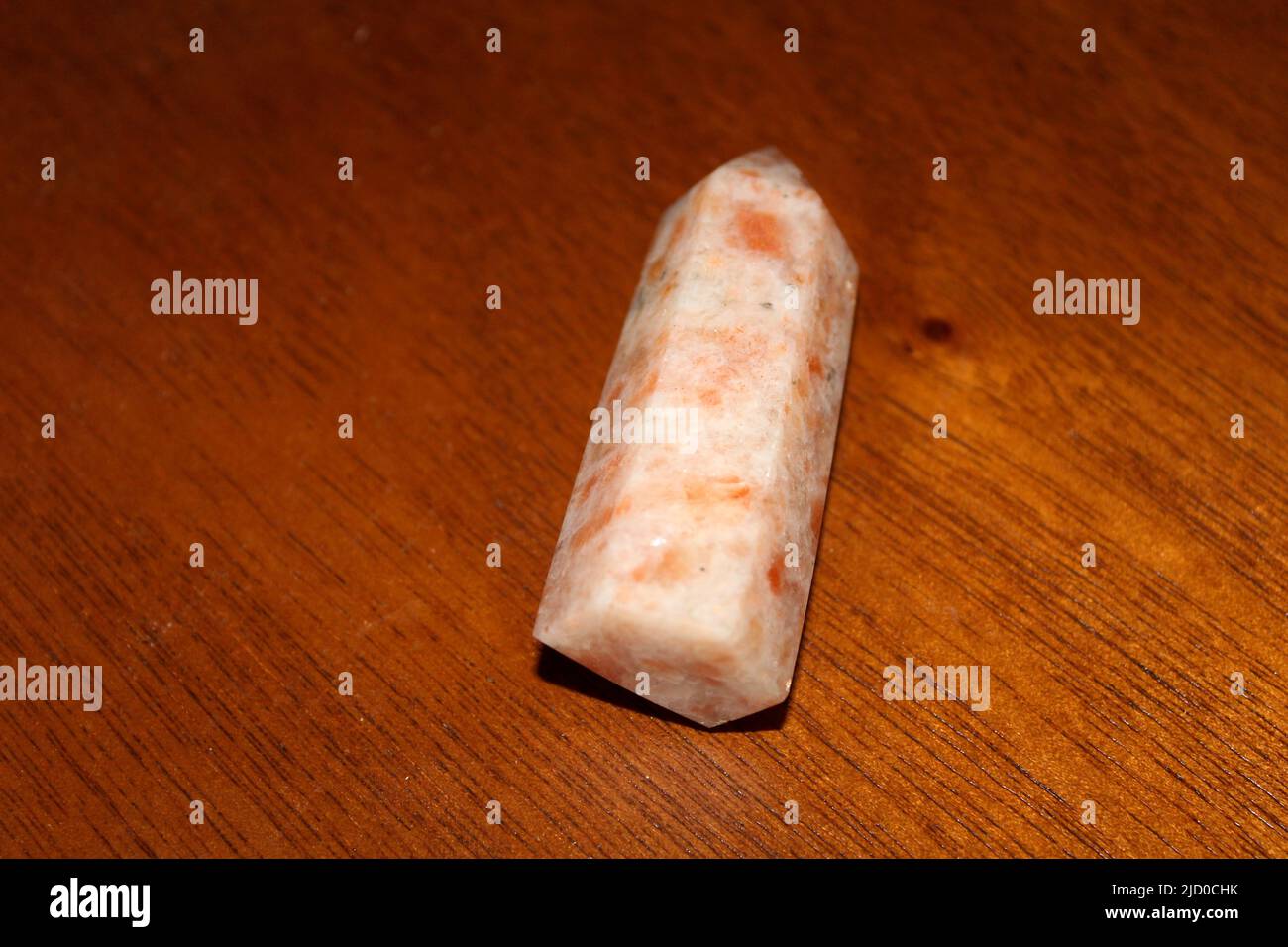Posa piatta di un punto di pietra solare lucido noto anche come cristallo della torre di pietra solare. Sunstone è una pietra di guarigione che funziona attraverso il fisico, spirituale, a Foto Stock