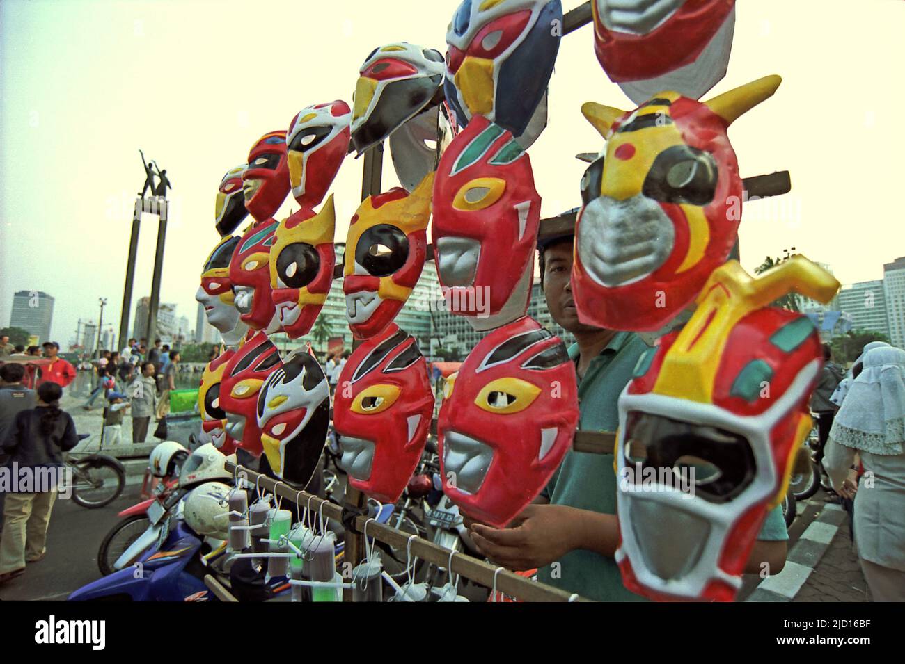 Un itinerante di maschere di personaggi immaginari come giocattoli per bambini in attesa di clienti a Bundaran HI (Hotel Indonesia Roundabout) durante il Carnevale di Giacarta 2004 nel centro di Jakarta, Jakarta, Indonesia. Foto Stock