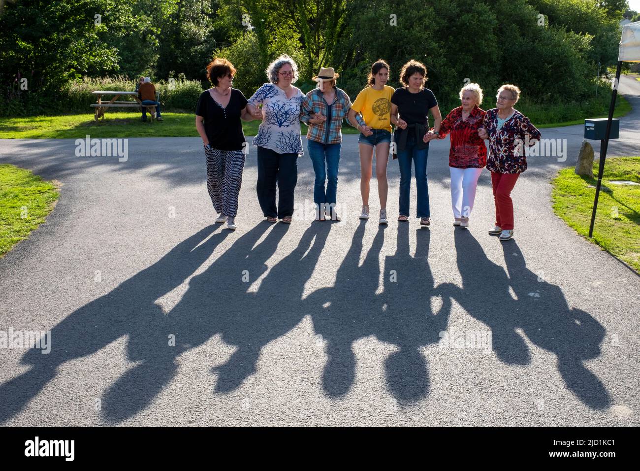 Un gruppo di donne che fanno una danza bretone locale al sole, Quinoualch villaggio Finistere, Bretagna, Francia Foto Stock