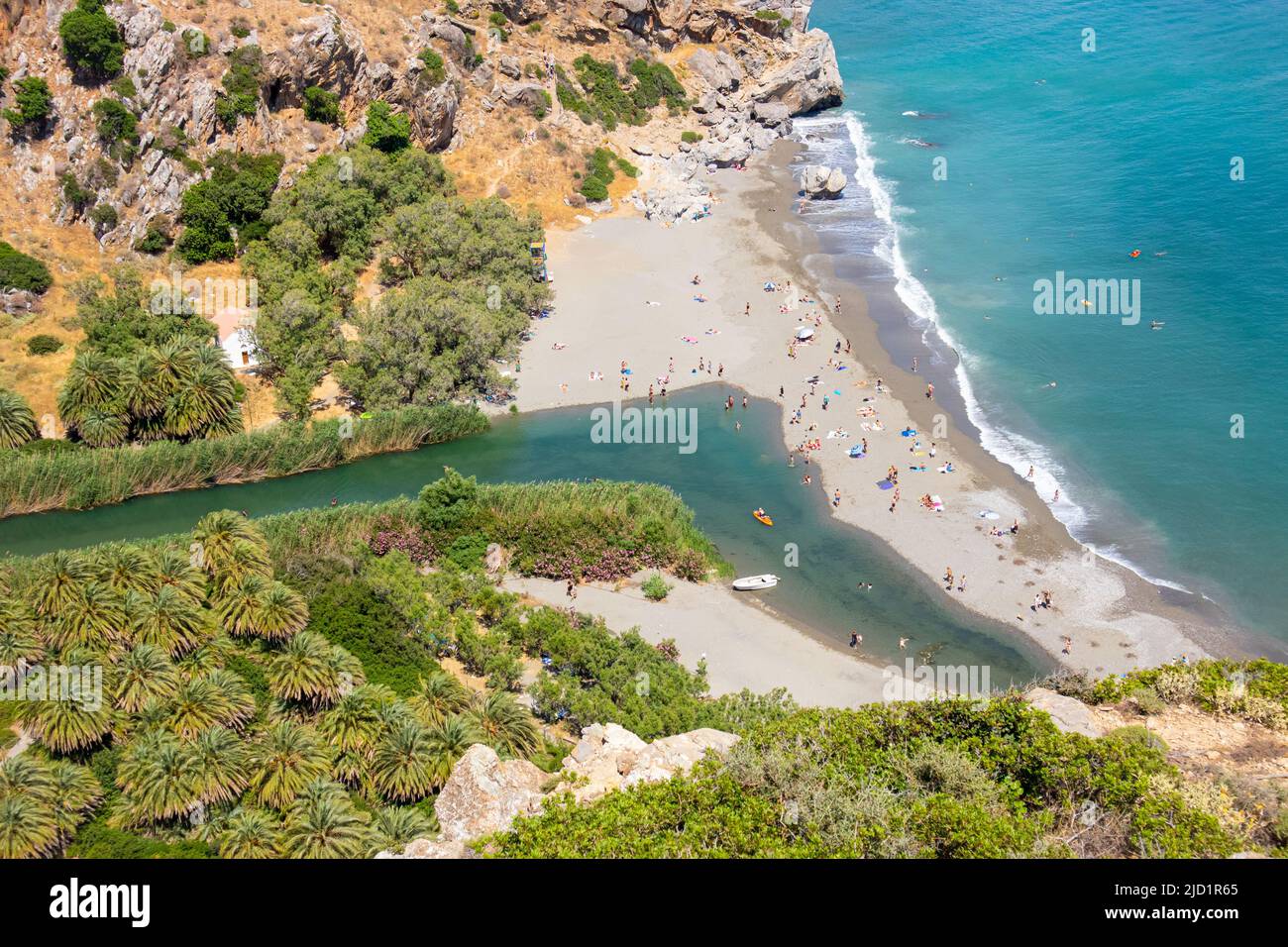 Pittoresca spiaggia di Preveli sull'isola di Creta, Grecia, Europa. Giornata estiva soleggiata. Mare blu e cielo. Valle vista dall'alto punto di vista. Palm Forest, riv Foto Stock