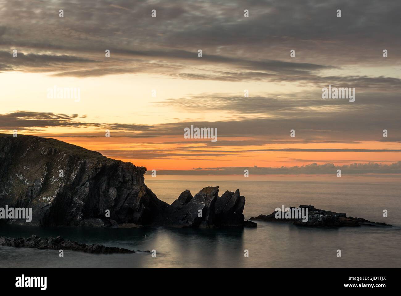 Galley Head, Cork, Irlanda. 15th giugno 2022. Una formazione rocciosa costiera posta contro la luce dell'alba al Galley Head, Co. Cork, Irlanda. - Immagine David Cr Foto Stock