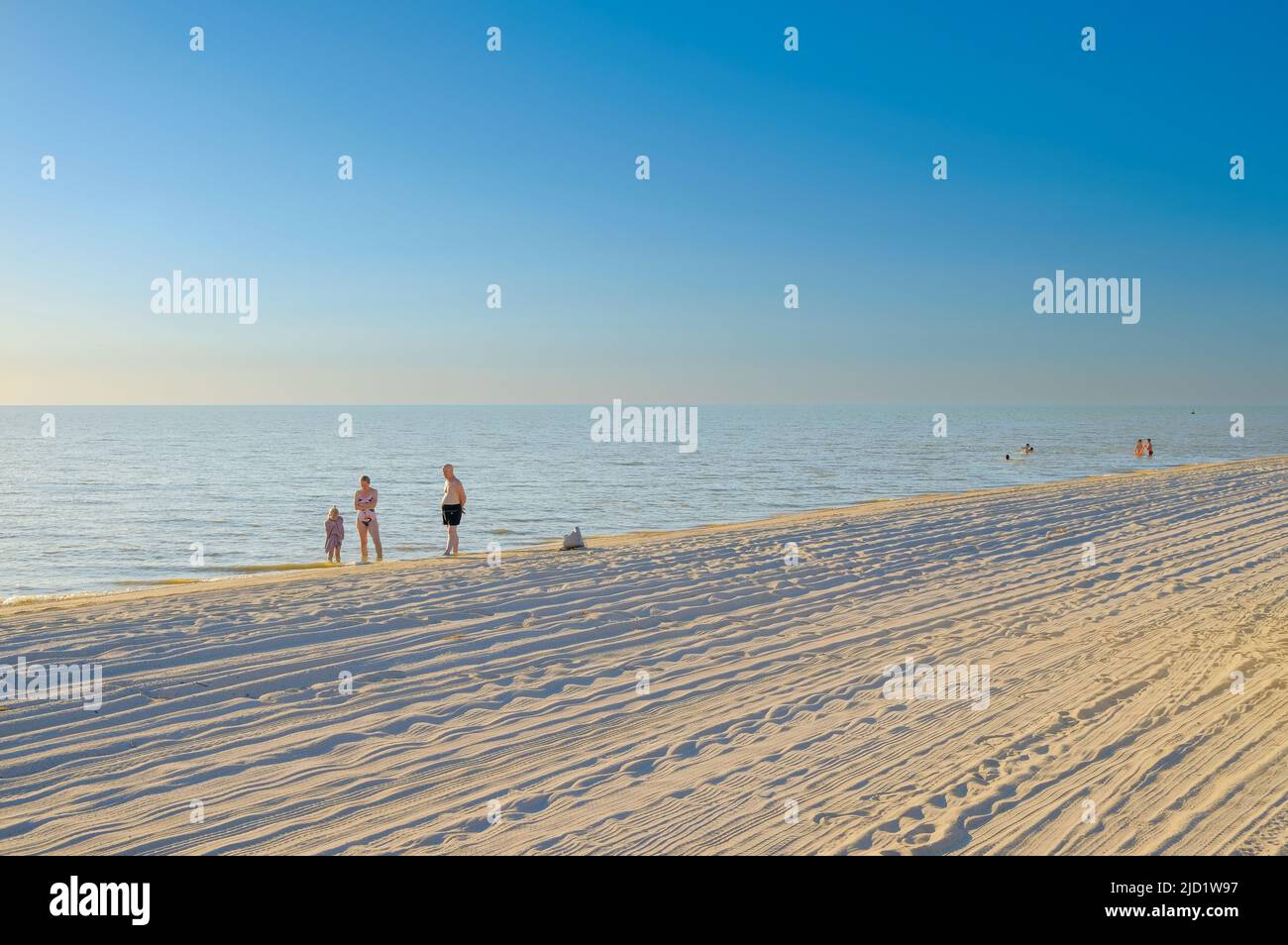 Regione di Krasnodar. Russia. Giugno 11, 2022. La gente prendisole sulla spiaggia di sabbia del mare di Azov in una giornata estiva soleggiata. Concetto di vacanza al mare. Foto Stock