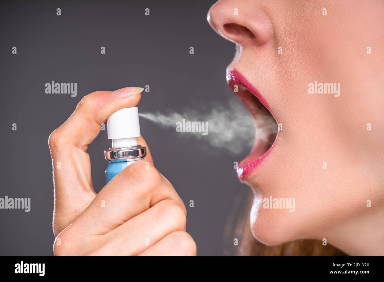 Primo piano di Una donna che applica spray respiratorio fresco Foto Stock