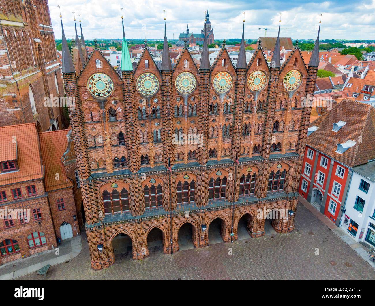 31 maggio 2022, Meclemburgo-Pomerania occidentale, Stralsund: Vista della facciata espositiva del municipio di Stralsund presso l'Alter Markt. I dischi ornamentali parzialmente dorati, del peso di circa 80 chilogrammi, furono realizzati secondo il modello tardo medievale intorno al 1880. Si presume che i dischi stellari simboleggino il regno dei cieli, che si erge come un ordine divino al di sopra dell'ordine umano terreno - il municipio con il suo concilio. Il municipio di Stralsund, patrimonio dell'umanità, è uno dei più importanti edifici secolari anseatici della regione baltica. Le due città anseatiche di Wismar e Stralsund Foto Stock