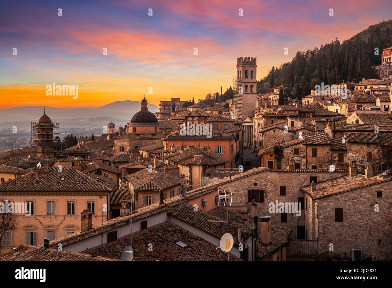 Assisi, Italia tetto collina skyline della città vecchia al crepuscolo. Foto Stock