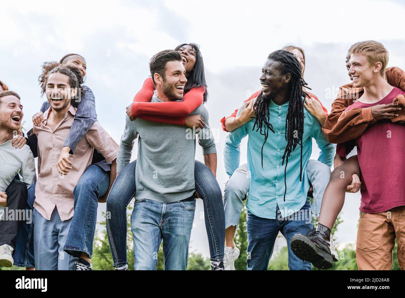 Felice gruppo multirazziale di amici divertirsi all'aperto - Vacanze estive e stile di vita di amicizia - Focus sul volto africano uomo Foto Stock