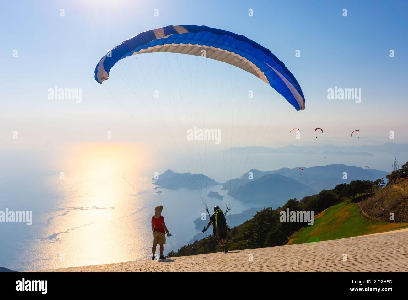 Fethiye, Mugla, Turchia - 28 2020 agosto: L'uomo con paracadute prepara il decollo dal monte Babadag. Concetto di parapendio. Foto Stock