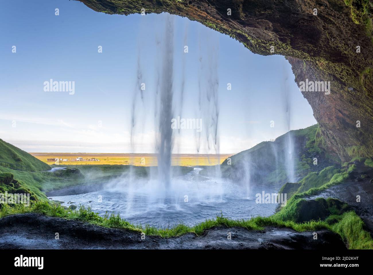Camminando dietro la cascata Seljalandsfoss in estate, Islanda Foto Stock