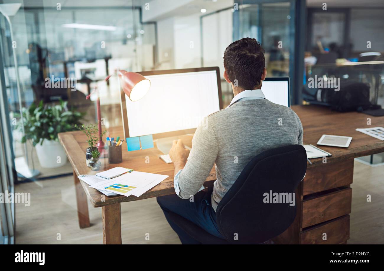 Egli rimane in cima al suo lavoro. Scatto corto di un uomo d'affari che lavora nel suo ufficio. Foto Stock