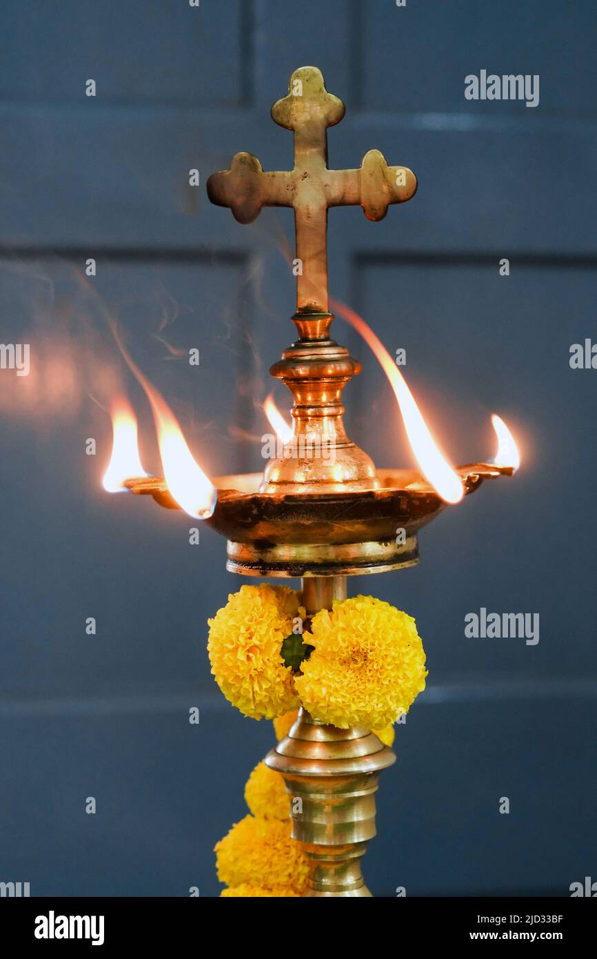 Lampada ad olio con croce cristiana in una chiesa della diocesi di Baruipur, India Foto Stock