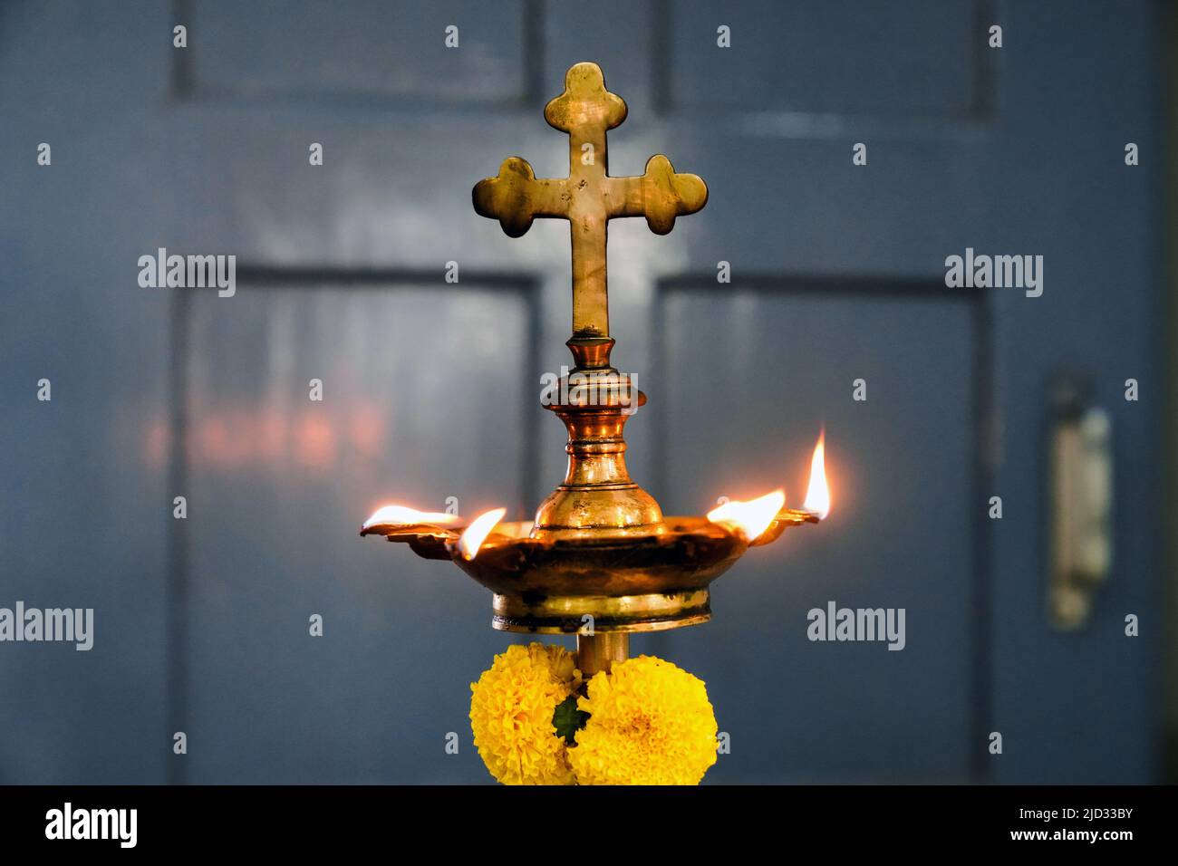 Lampada ad olio con croce cristiana in una chiesa della diocesi di Baruipur, India Foto Stock
