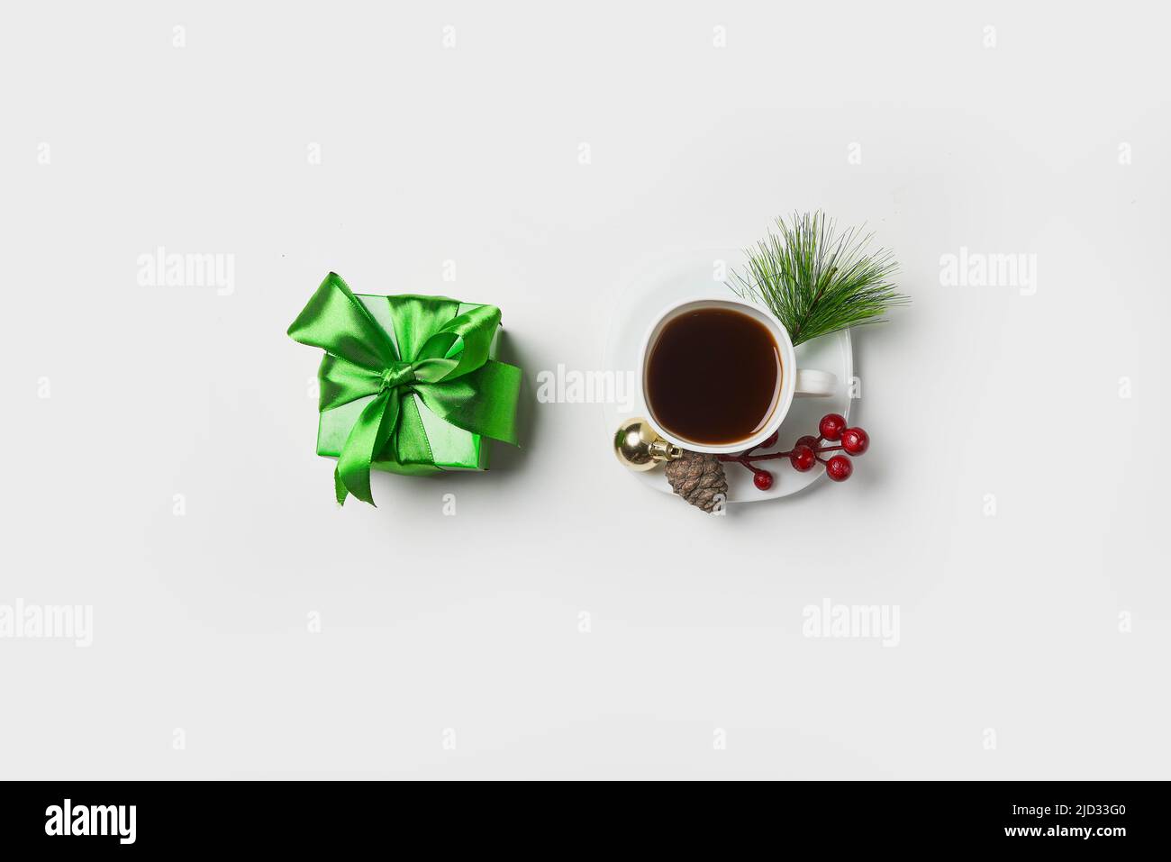 Tazza di caffè espresso. Tazza di caffè con ornamenti natalizi e confezione regalo verde su sfondo bianco. Minimalismo Foto Stock