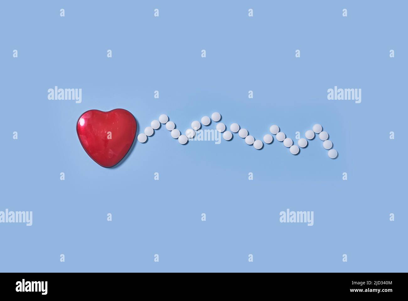 Medicina, salute e farmacia concetto - pillole e di farmaci in forma di cuore e ritmo cardiaco su sfondo blu Foto Stock