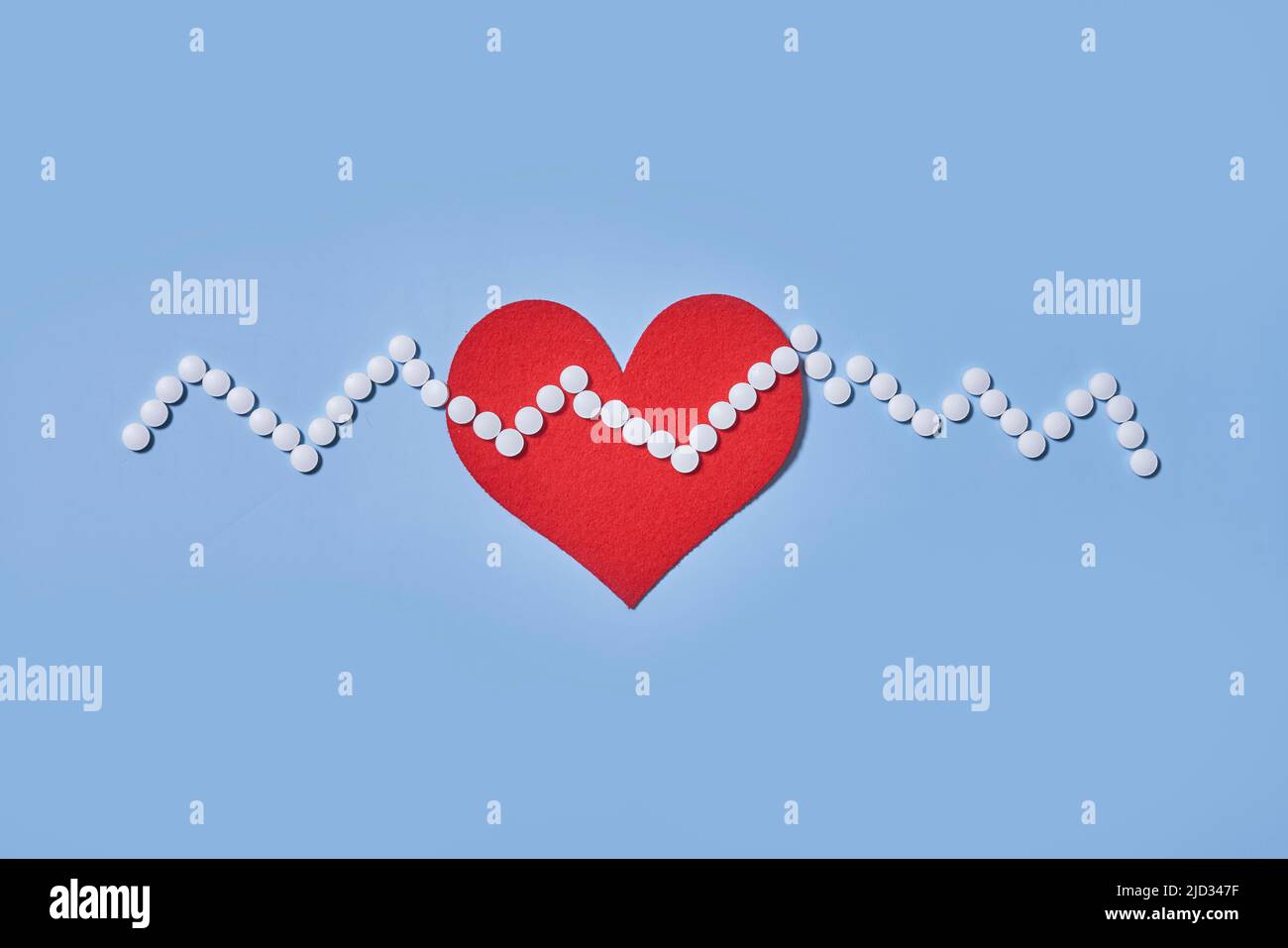 Medicina, salute e farmacia concetto - pillole e di farmaci in forma di cuore e ritmo cardiaco e su sfondo blu Foto Stock