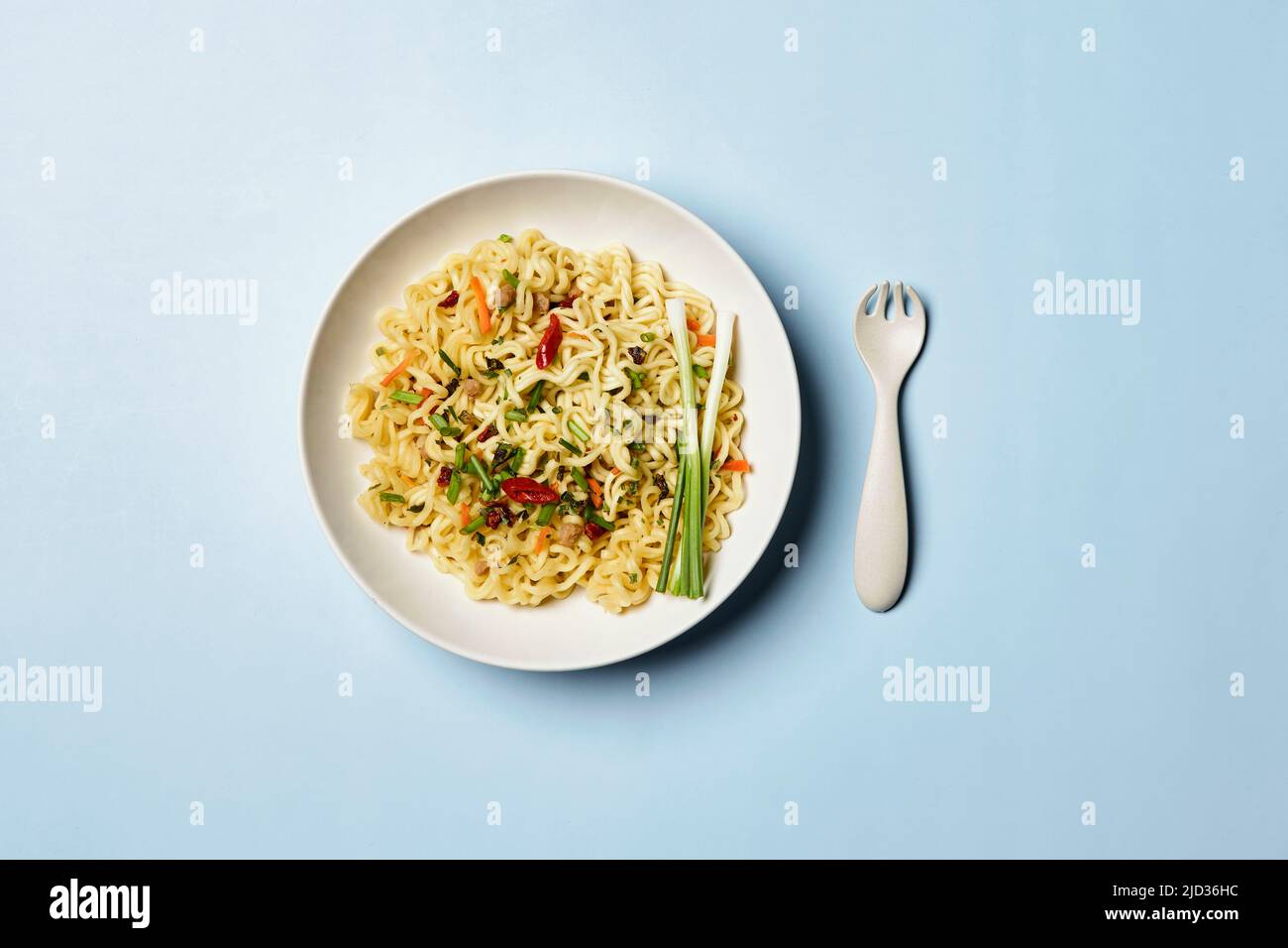 Composizione immediata degli spaghetti. Spaghetti e verdure fresche e spezie su sfondo blu brillante Foto Stock
