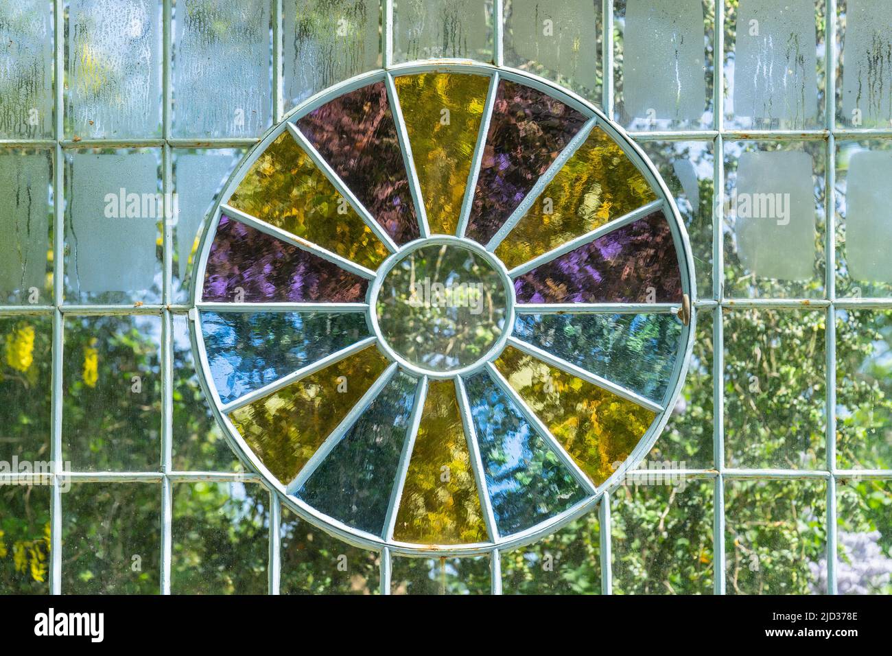 Una parete di vetro di una serra con una finestra di vetro multicolore Foto Stock