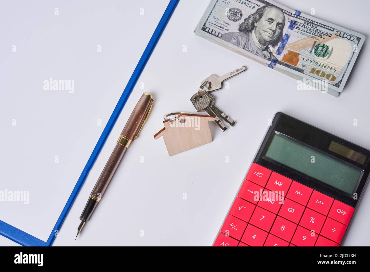 Casa poggiante sul concetto di calcolatore per calcolatore di ipoteca, finanze domestiche o risparmio per una casa sul backgraund bianco. Foto Stock