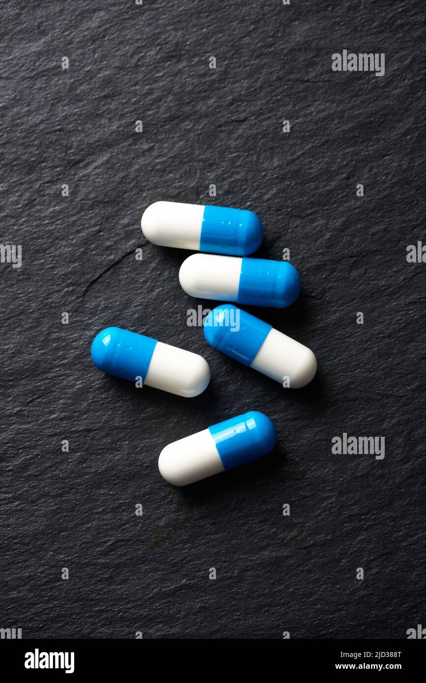 Supplementi sportivi (creatina capsule) su sfondo di pietra scura. Vista dall'alto. Primo piano. Spazio di copia. Foto Stock