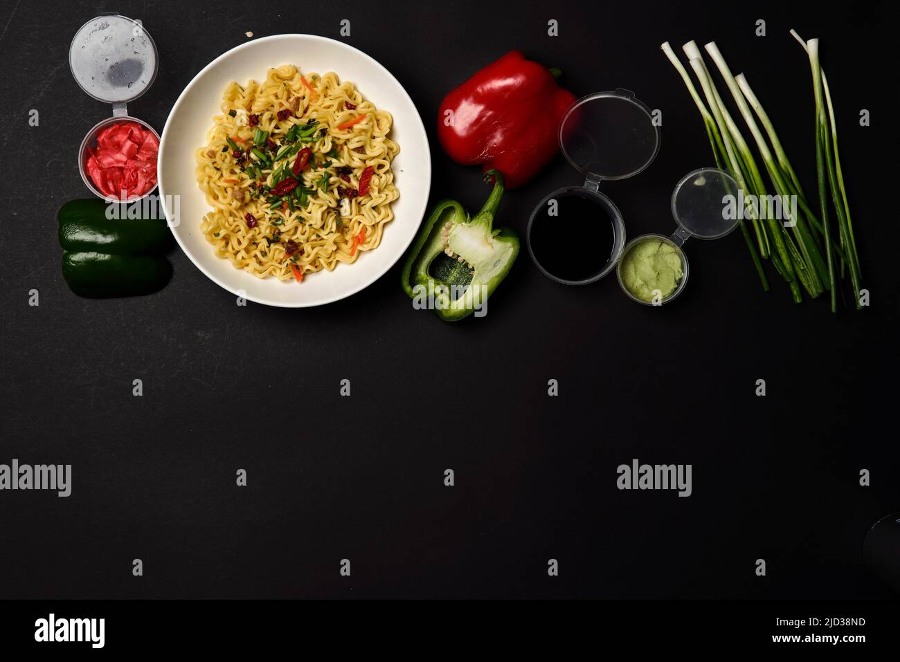 Composizione immediata degli spaghetti. Spaghetti e verdure fresche e spezie su sfondo nero brillante Foto Stock