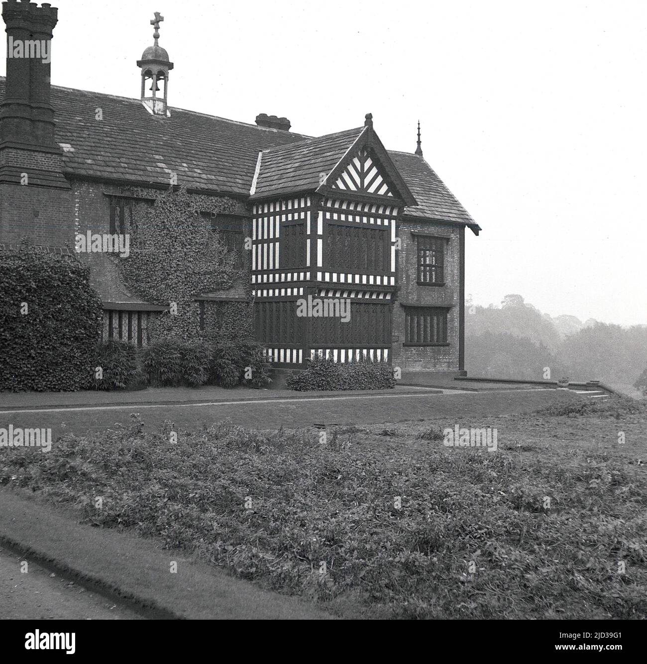 1940s, storico, il retro di Bramall Hall, Stockport, Inghilterra, Regno Unito. Una casa padronale Tudor a graticcio che risale al 14th secolo, con aggiunte successive, la casa e il parco circostante è stato acquistato dall'autorità locale nel 1935 e divenne un museo. La famiglia Davenport, che si ritiene abbia costruito la casa, ha tenuto il maniero per oltre 500 anni. Foto Stock