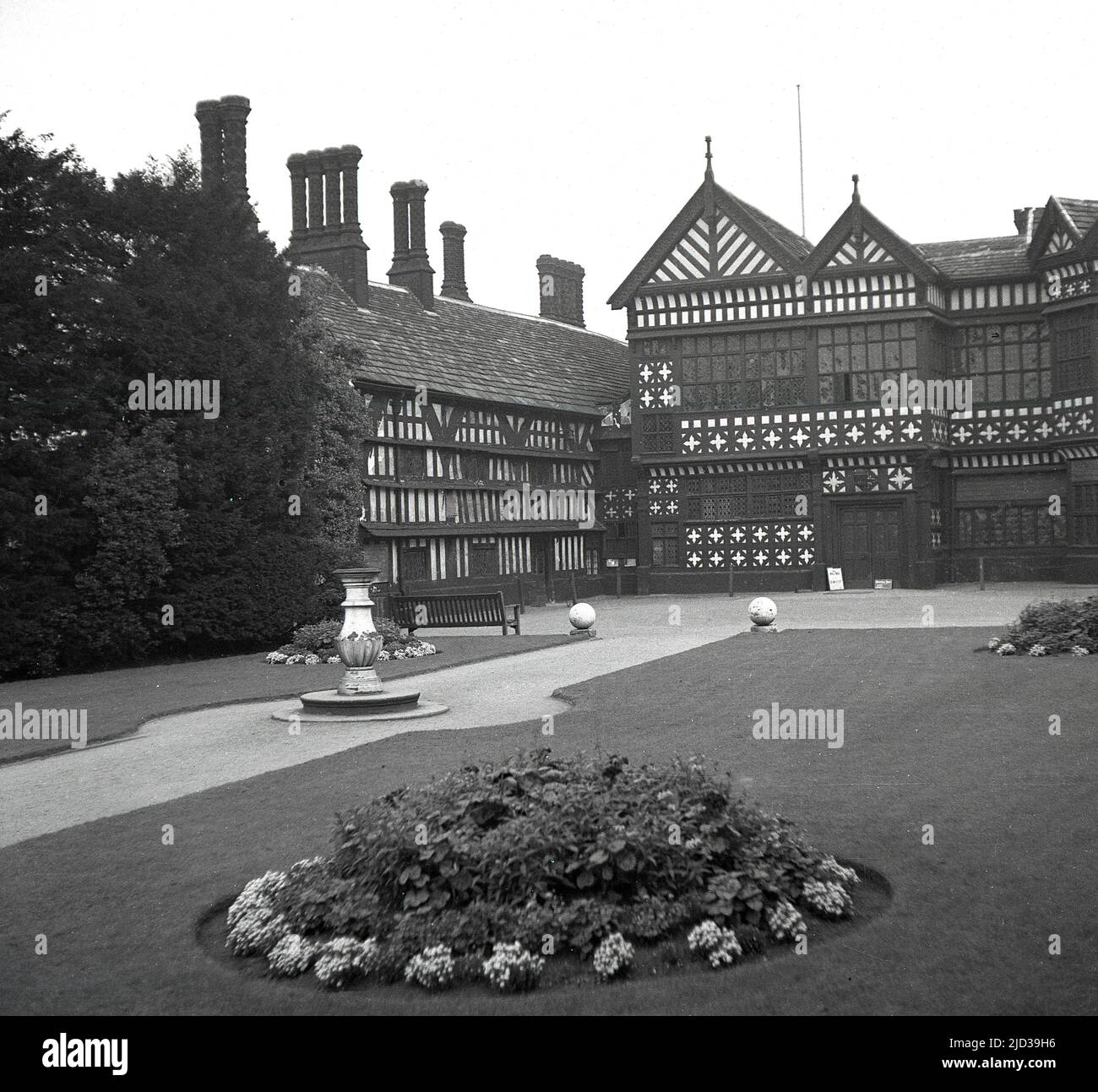 1940s, storico, il retro di Bramall Hall, Stockport, Inghilterra, Regno Unito. Una casa padronale Tudor a graticcio che risale al 14th secolo, con aggiunte successive, la casa e il parco circostante è stato acquistato dall'autorità locale nel 1935 e divenne un museo. La famiglia Davenport, che si ritiene abbia costruito la casa, ha tenuto il maniero per oltre 500 anni. Qui si vede una vista dal 1940s da ovest, dell'ingresso principale, cortile, ala sud e la Grande Sala nel centro. Foto Stock