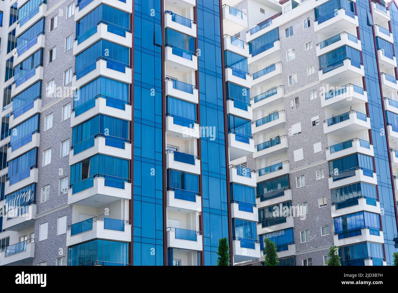 Vista astratta di un complesso residenziale multi-familiare di condomini con finestre balconi dipinti in blu e bianco. Architettura di sfondo. Foto Stock